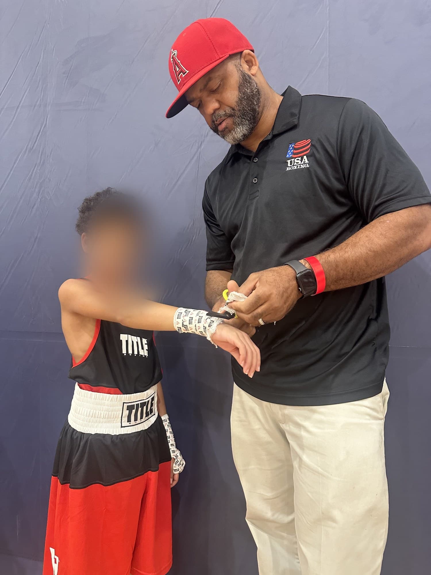 Coach Keith wrapping a young boxer's hands at FC High Performance